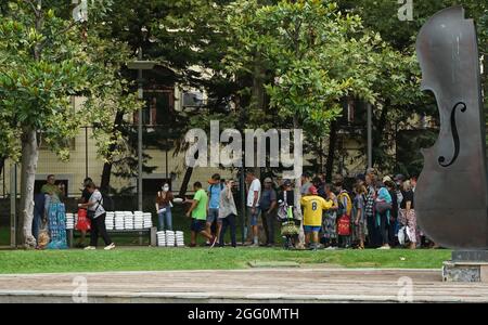 Bucarest, Roumanie - 26 août 2021 : les pauvres font la queue pour recevoir une aide alimentaire en plein centre de Bucarest, sur la place de l'université. Banque D'Images