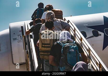 Les évacués embarquent à bord d'un avion pour évacuation à l'aéroport international Hamid Karzaï, en Afghanistan, en août 25. Les membres du service américain aident le ministère d'État à effectuer une opération d'évacuation non combattantes (NEO) en Afghanistan. (É.-U. Photo du corps marin par Cpl. Davis Harris) Banque D'Images