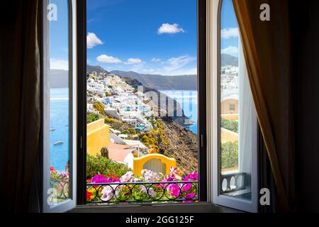 Vue depuis la fenêtre du complexe surplombant la ville blanchie à la chaux d'Oia, Santorin, Grèce et la mer Égée. Banque D'Images