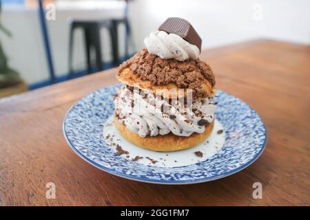 petit pain, pâte de choux avec garniture en poudre de chocolat ou eclair pour servir Banque D'Images