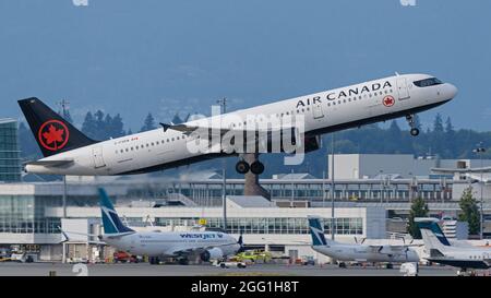 Richmond, Colombie-Britannique, Canada. 25 août 2021. Un Airbus A321-200 d'Air Canada (C-FGKN) part de l'aéroport international de Vancouver. En arrière-plan : les avions WestJet au terminal intérieur de l'aéroport. (Image de crédit : © Bayne Stanley/ZUMA Press Wire) Banque D'Images