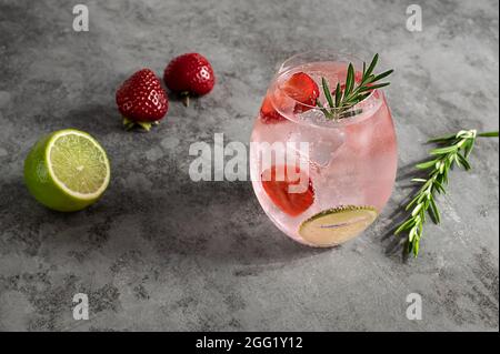 Gin rose haut de gamme avec fraise, lime et romarin. Banque D'Images