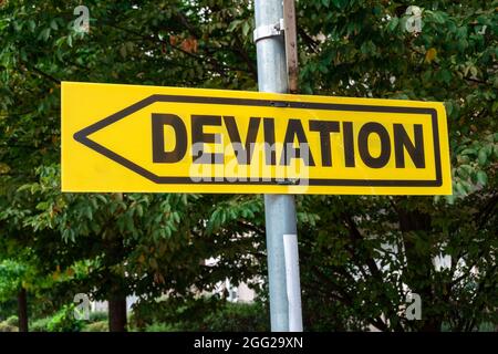 Panneau de signalisation jaune avec une flèche de direction et le mot DÉVIATION écrit en français. Concepts de changement et de modification Banque D'Images