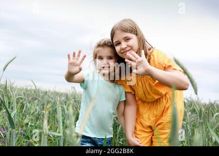 Deux petites filles s'embrassant sur un terrain d'été. Joyeuses sœurs sur la prairie d'été Banque D'Images