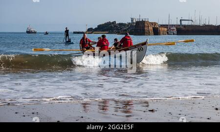 North Berwick, East Lothian, Écosse, Royaume-Uni 28 août 2021. Coastal Rowing Regatta: L'événement annuel, annulé l'année dernière, a lieu cette année sous une forme réduite avec seulement sept clubs de la partie sud du Firth of Forth participant. Photo : les skiffs sont lancés pour la première course Banque D'Images