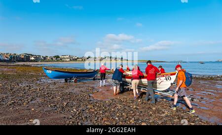 North Berwick, East Lothian, Écosse, Royaume-Uni 28 août 2021. Coastal Rowing Regatta: L'événement annuel, annulé l'année dernière, a lieu cette année sous une forme réduite avec seulement sept clubs de la partie sud du Firth of Forth participant. Photo : les skiffs sont lancés pour la première course Banque D'Images