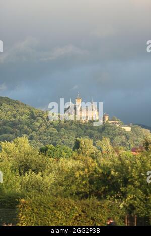 Wernigerode, Allemagne. 27 août 2021. Dans la lumière du soleil du soir, des nuages sombres passent au-dessus du château. Dans les jours à venir, il reste très changeant avec le soleil et la pluie. Credit: Matthias Bein/dpa-Zentralbild/ZB/dpa/Alay Live News Banque D'Images