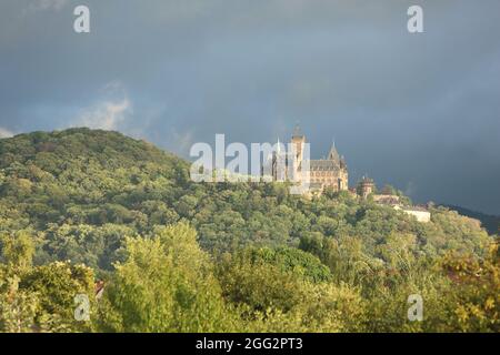 Wernigerode, Allemagne. 27 août 2021. Dans la lumière du soleil du soir, des nuages sombres passent au-dessus du château. Dans les jours à venir, il reste très changeant avec le soleil et la pluie. Credit: Matthias Bein/dpa-Zentralbild/ZB/dpa/Alay Live News Banque D'Images