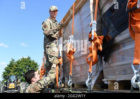 Les aviateurs de la US Air Force de 1re classe Leonardo Ramos et Derek Monie, 52e Escadron de préparation logistique spécialistes du transport terrestre, sécurisent les sangles sur un camion transportant des lits à destination de la base aérienne de Ramstein, en Allemagne, le 24 août 2021, sur la base aérienne de Spangdahlem, en Allemagne. Les lits de camp ont été envoyés à Ramstein AB pour aider les efforts d'évacuation de l'Afghanistan par le ministère de la Défense des États-Unis. (É.-U. Photo de la Force aérienne par Tech. Sgt. Warren Spearman) Banque D'Images