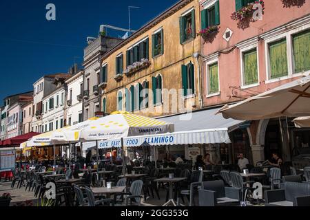 Rangée de bâtiments multicolores colorés sur la rue principale Corso del Popolo dans le centre historique de la ville de Chioggia, ciel bleu en été, Banque D'Images