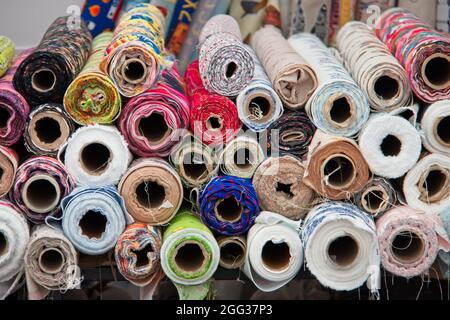 Vue de bout en bout des rouleaux de tissu avec des tissus de couleur. Banque D'Images