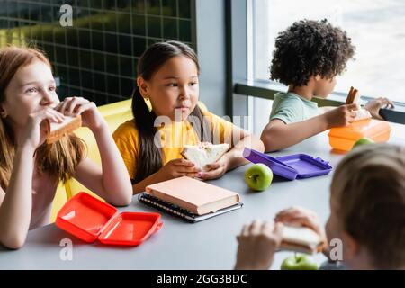 des enfants multiethniques déjeunent dans le restaurant de l'école Banque D'Images