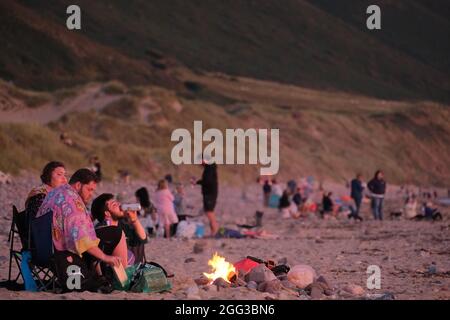 Feux de camp d'été sur la plage de Llangennith, péninsule de Gower, près de Swansea, Royaume-Uni. Remarque : les images peuvent présenter une légère douceur et un certain bruit de signal, tel qu'il est pris avec des paramètres ISO très élevés. Ne convient pas à une reproduction plus large. Banque D'Images