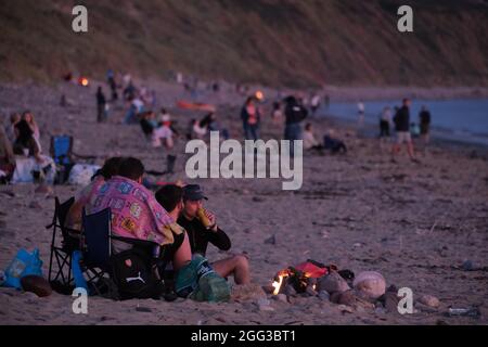 Feux de camp d'été sur la plage de Llangennith, péninsule de Gower, près de Swansea, Royaume-Uni. Remarque : les images peuvent présenter une légère douceur et un certain bruit de signal, tel qu'il est pris avec des paramètres ISO très élevés. Ne convient pas à une reproduction plus large. Banque D'Images