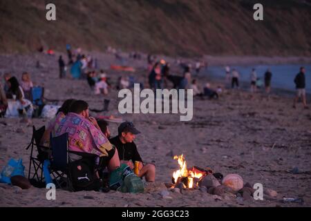 Feux de camp d'été sur la plage de Llangennith, péninsule de Gower, près de Swansea, Royaume-Uni. Remarque : les images peuvent présenter une légère douceur et un certain bruit de signal, tel qu'il est pris avec des paramètres ISO très élevés. Ne convient pas à une reproduction plus large. Banque D'Images