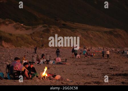 Feux de camp d'été sur la plage de Llangennith, péninsule de Gower, près de Swansea, Royaume-Uni. Remarque : les images peuvent présenter une légère douceur et un certain bruit de signal, tel qu'il est pris avec des paramètres ISO très élevés. Ne convient pas à une reproduction plus large. Banque D'Images