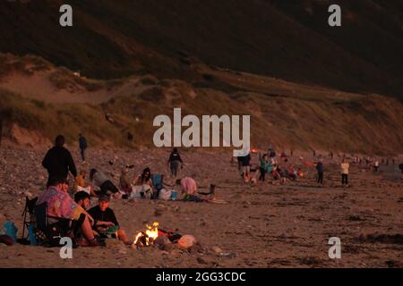 Feux de camp d'été sur la plage de Llangennith, péninsule de Gower, près de Swansea, Royaume-Uni. Remarque : les images peuvent présenter une légère douceur et un certain bruit de signal, tel qu'il est pris avec des paramètres ISO très élevés. Ne convient pas à une reproduction plus large. Banque D'Images