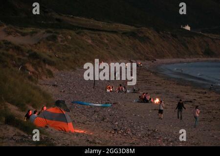 Feux de camp d'été sur la plage de Llangennith, péninsule de Gower, près de Swansea, Royaume-Uni. Remarque : les images peuvent présenter une légère douceur et un certain bruit de signal, tel qu'il est pris avec des paramètres ISO très élevés. Ne convient pas à une reproduction plus large. Banque D'Images