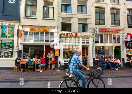 Amsterdam, Hollande, scènes de rue, rangée de magasins, touristes partageant des repas sur la terrasse des restaurants Fast Food, vélos Banque D'Images