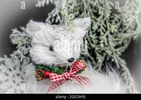 Décoration de renard de Noël blanc avec noeud de Vichy rouge sur fond de bokeh hivernal Banque D'Images