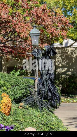 Halloween Decoration-Grim Reaper est suspendu sur le poteau de lampe avec une araignée géante à ses pieds Banque D'Images