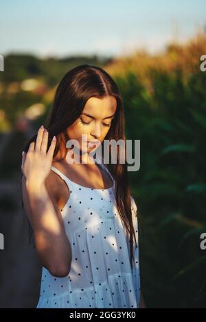 Jeune belle femme en robe blanche dans champ de maïs. Banque D'Images