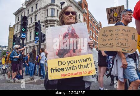 Londres, Royaume-Uni. 28 août 2021. Un activiste détient un écriteau anti-McDonald's à l'extérieur du marché Smithfield pendant la Marche nationale des droits des animaux. Des militants et des organisations des droits des animaux ont défilé dans la City de Londres pour exiger la fin de toute exploitation animale. (Crédit : Vuk Valcic / Alamy Live News) Banque D'Images