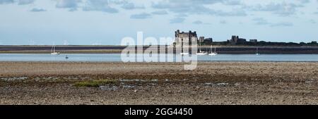 Yachts et château de Piel sur l'île de Piel vu à marée basse de l'île de Roa sur la péninsule de Furness Banque D'Images