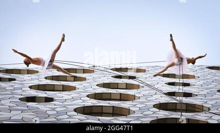 Londres, Royaume-Uni, 28 août 2021. Deux danseurs de ballet de formation classique de la compagnie de danse catalane Delrevés présentent 'finale', ballet aérien suspendu à mi-air à une hauteur à couper le souffle, avec des extraits du lac Swan et du casse-noisette, le long de la façade du bâtiment de l'université de Ravensbourne. « finale » fait partie d'une série de représentations de « Dance by Design », toutes dans le cadre du festival international de Greenwich et des Docklands. Le nouveau parc en hauteur situé au bord de la rivière Tide, à Londres, accueille des spectacles de danse qui font partie du festival international de Greenwich et des Docklands. Credit: Imagetraceur/Alamy Live News Banque D'Images