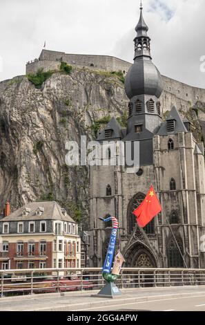 Dinant, Wallonie, Belgique - 8 août 2021 : fort de la Citadelle. Drapeau communiste chinois, statue de saxophone sur le thème du drapeau américain devant la Collégiale notre D. Banque D'Images