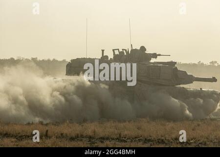 Un char de combat principal australien M1A1 Abrams se dirige vers objective Bobcat pour les répétitions pendant l'exercice Koolendong à la zone d'entraînement de Bradshaw Field, territoire du Nord, Australie, 25 août 2021. Les soldats américains des Marines et de l'armée australienne ont participé à des attaques montées et démontées pendant l'exercice. Des exercices comme Koolendong valident la capacité de la Marine Rotational Force-Darwin et de la Défense australienne à mener des opérations expéditionnaires avancées avec des capacités innovantes combinées ; et par leur engagement commun, sont prêts à répondre à une crise ou à une éventualité dans la région Indo-Pacifique. Banque D'Images