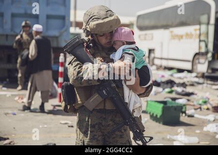 210828-M-AU949-0271 AÉROPORT INTERNATIONAL HAMID KARZAÏ (Afghanistan) (28 août 2021) UNE marine américaine avec la 24e unité expéditionnaire maritime (UMM) transporte un bébé comme processus de la famille par le biais du Centre de contrôle d'évacuation (ECC) lors d'une évacuation à l'aéroport international Hamid Karzaï, Kaboul, Afghanistan, août 28. Les membres du service américain aident le ministère d'État à effectuer une opération d'évacuation (NEO) non combattue en Afghanistan. (É.-U. Photo du corps marin par le sergent d'état-major. Victor Mancilla) Banque D'Images