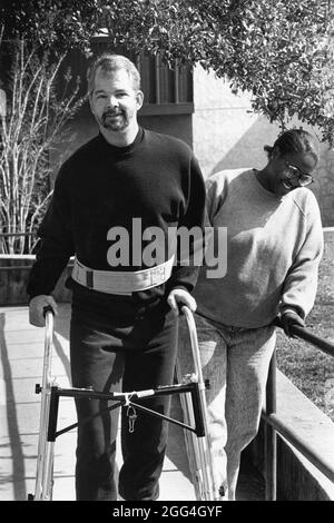 Austin Texas USA, 1993 : un homme qui a subi des lésions cérébrales permanentes dans un accident de vélo utilise un déambulateur pendant une séance d'exercice avec un physiothérapeute. ©Bob Daemmrich Banque D'Images