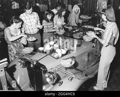 Circa 1988 : les convives s'aident eux-mêmes pour les ingrédients du bar à salades exposés dans une voiture vintage dans un restaurant à thème populaire. ©Bob Daemmrich Banque D'Images