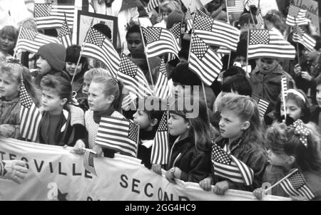 Gatesville Texas USA, 1991 : les écoliers tiennent une bannière et brandissent de petits drapeaux américains lors d'un rassemblement patriotique « soutenez les troupes » dans cette petite ville du Texas près de Fort Hood, une grande base d'entraînement de l'armée. ©Bob Daemmrich Banque D'Images