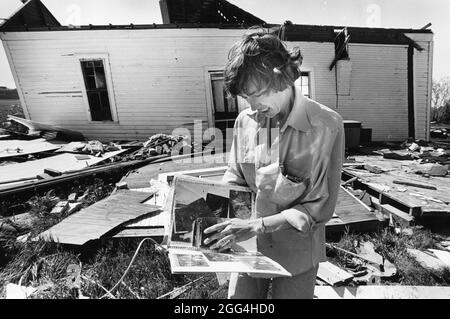 Williamson County Texas USA, 1987 : femme regarde à travers l'album photo récupéré de sa maison endommagée par la tornade près d'Austin. ©Bob Daemmrich Banque D'Images