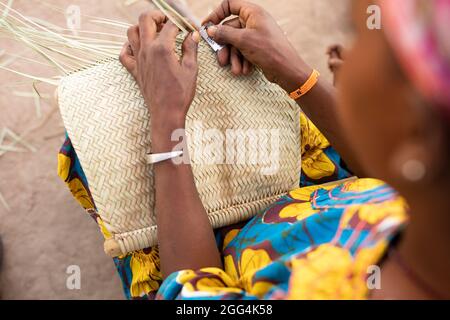 Une femme Fulani déménage à la main des matts et des fans de palmier séché pour la subsistance de sa famille dans la région de Ségou, Mali, Afrique de l'Ouest. Banque D'Images