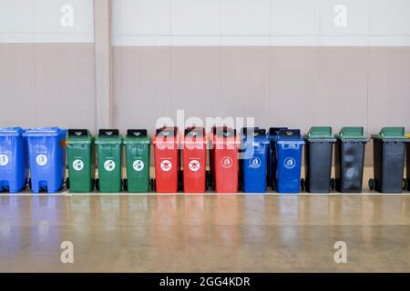 Une rangée de conteneurs à ordures en plastique industriel multicolores. Banque D'Images