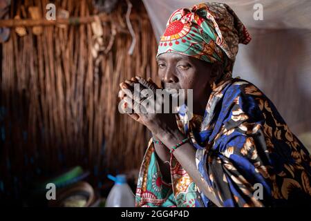 Une femme est assise dans son abri de fortune dans le camp de Senou, à la limite sud de Bamako, au Mali, où les personnes déplacées qui ont fui la violence dans le nord du pays ont cherché la sécurité. Banque D'Images