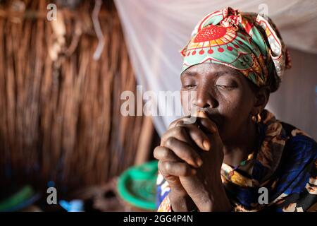 Une femme est assise dans son abri de fortune dans le camp de Senou, à la limite sud de Bamako, au Mali, où les personnes déplacées qui ont fui la violence dans le nord du pays ont cherché la sécurité. Banque D'Images