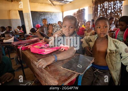 Le camp de Senou se trouve à la limite sud de Bamako, la capitale du Mali. C'est l'un des huit camps informels autour de la ville et, en soi, il abrite 223 familles et un peu plus de 1 000 personnes déplacées. Les familles qui vivent ici ont fui la violence et l'insurrection dans le nord et le centre du pays. Parce que la plupart d'entre eux n'ont pas de moyens de revenu ou de source régulière de nourriture, la faim est un défi quotidien et la malnutrition de sa population reste endémique. Ici, les enfants apprennent dans la seule école primaire du camp, enseignée par Mme Asmatou Coulibably. Banque D'Images