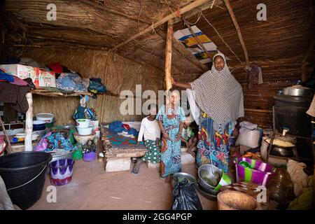 Le camp de Senou se trouve à la limite sud de Bamako, la capitale du Mali. C'est l'un des huit camps informels autour de la ville et, en soi, il abrite 223 familles et un peu plus de 1 000 personnes déplacées. Les familles qui vivent ici ont fui la violence et l'insurrection dans le nord et le centre du pays. Parce que la plupart d'entre eux n'ont pas de moyens de revenu ou de source régulière de nourriture, la faim est un défi quotidien et la malnutrition de sa population reste endémique. Ici, Fatima Bolly (33) est assise à l'intérieur de son abri de fortune avec trois de ses enfants. Banque D'Images