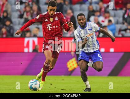 Munich, Allemagne. 28 août 2021. Jamal Musiala (L) du Bayern Munich contrôle le ballon sous la défense de Deyovaisio Zeefuik de Hertha lors d'un match allemand Bundesliga entre le Bayern Munich et Hertha BSC à Munich, Allemagne, 28 août 2021. Credit: Philippe Ruiz/Xinhua/Alay Live News Banque D'Images