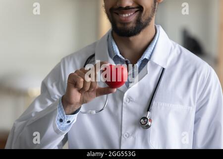 Gros plan un médecin africain millénaire tenant une figure de coeur. Banque D'Images