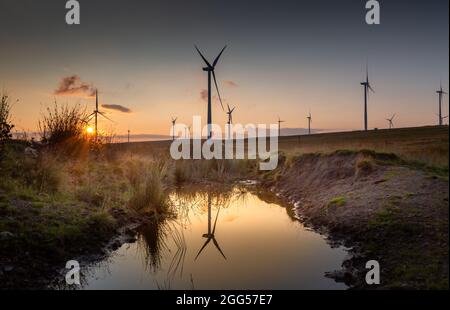 Coucher de soleil à la ferme éolienne de Mynydd y Betws sur la terre commune à l'est d'Ammanford dans le Carmarthenshire, pays de Galles, Royaume-Uni Banque D'Images