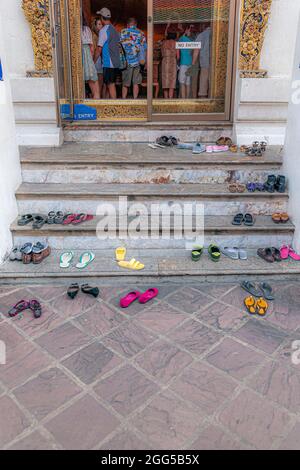 Paires de chaussures laissées sur les marches d'un bâtiment dans le complexe du temple Wat Pho à Bangkok en Thaïlande en Asie du Sud-est. Banque D'Images