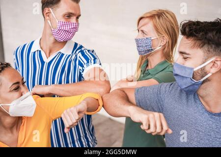 Les jeunes amis multiraciaux se cognent les coudes au lieu d'être salués avec un câlin - concentrez-vous sur les bras centraux Banque D'Images