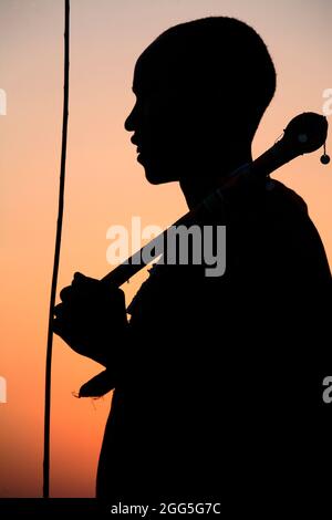 Silhouette d'un homme Massaï au coucher du soleil, Ngogongoro Conservation Area, Tanzanie Banque D'Images
