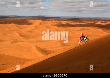 Biker sur les dunes à Erg Chebbi, Merzouga, Maroc Banque D'Images