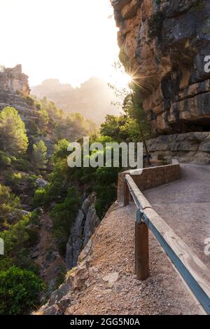 Sentier de la rivière Borosa avec le sunstar peeking des rochers de montagne accidentés, Sierra de Cazorla. Banque D'Images